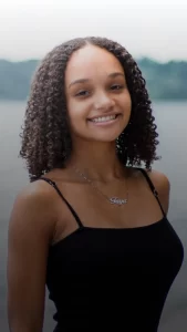 A young woman smiling confidently with straight teeth from clear aligners in Plantation.