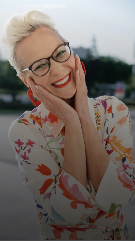 A mature woman smiling after dental implant treatment.