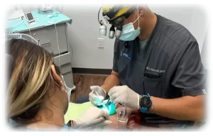 A dentist examining a patient of in an exam room.